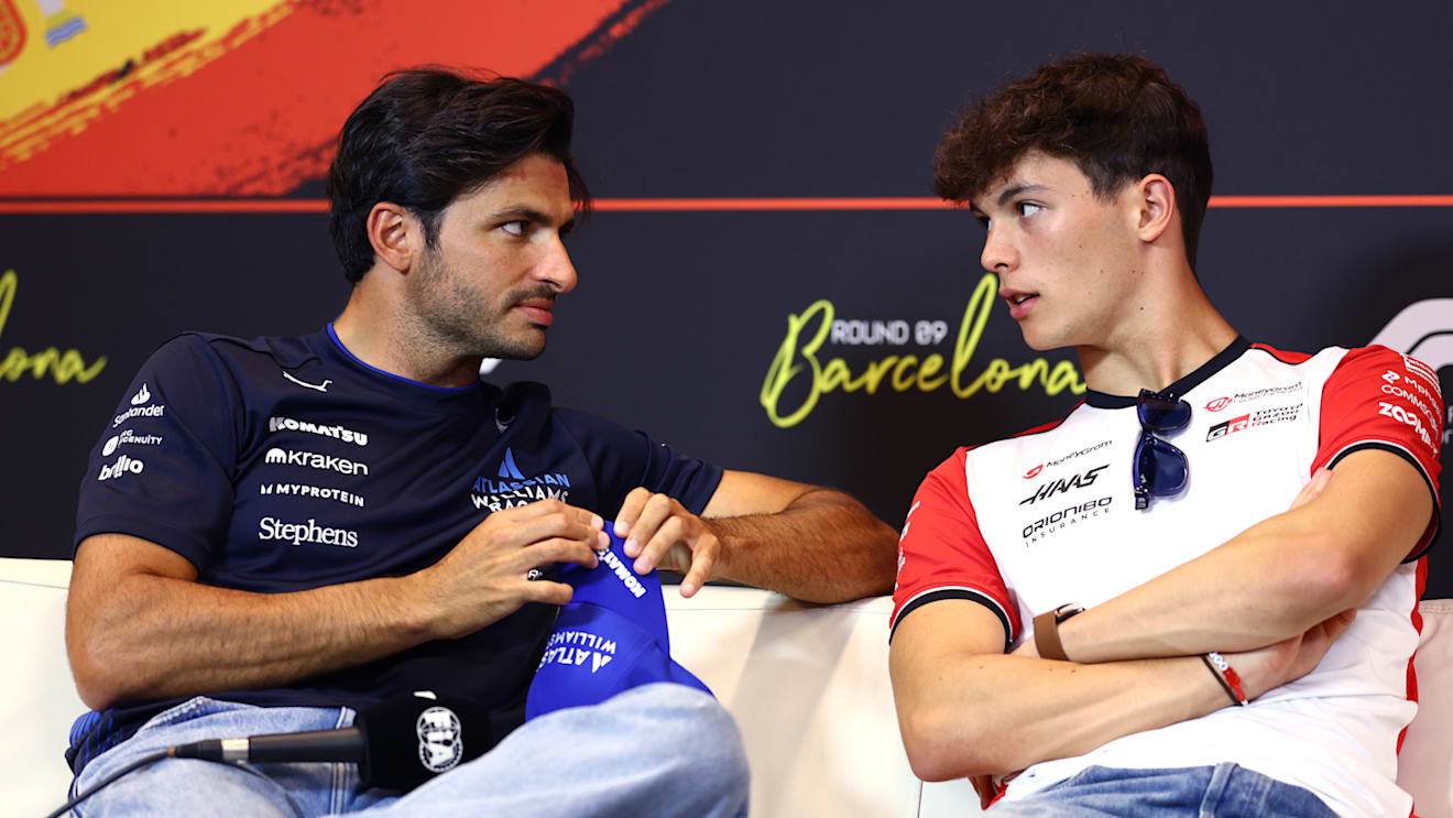 BARCELONA, SPAIN - MAY 29: Carlos Sainz of Spain and Williams and Oliver Bearman of Great Britain and Haas F1 talk in the Drivers Press Conference during previews ahead of the F1 Grand Prix of Spain at Circuit de Barcelona-Catalunya on May 29, 2025 in Barcelona, Spain. (Photo by Clive Rose/Getty Images)
